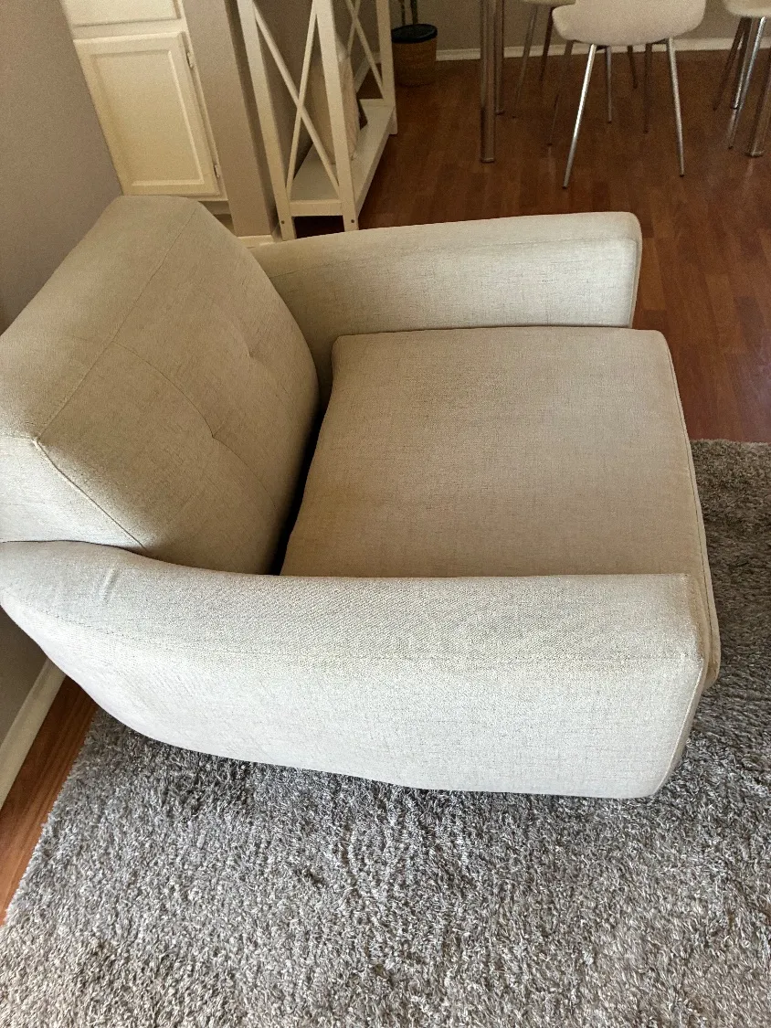 The cleaned accent chair viewed from across the room, showing the fully refreshed fabric